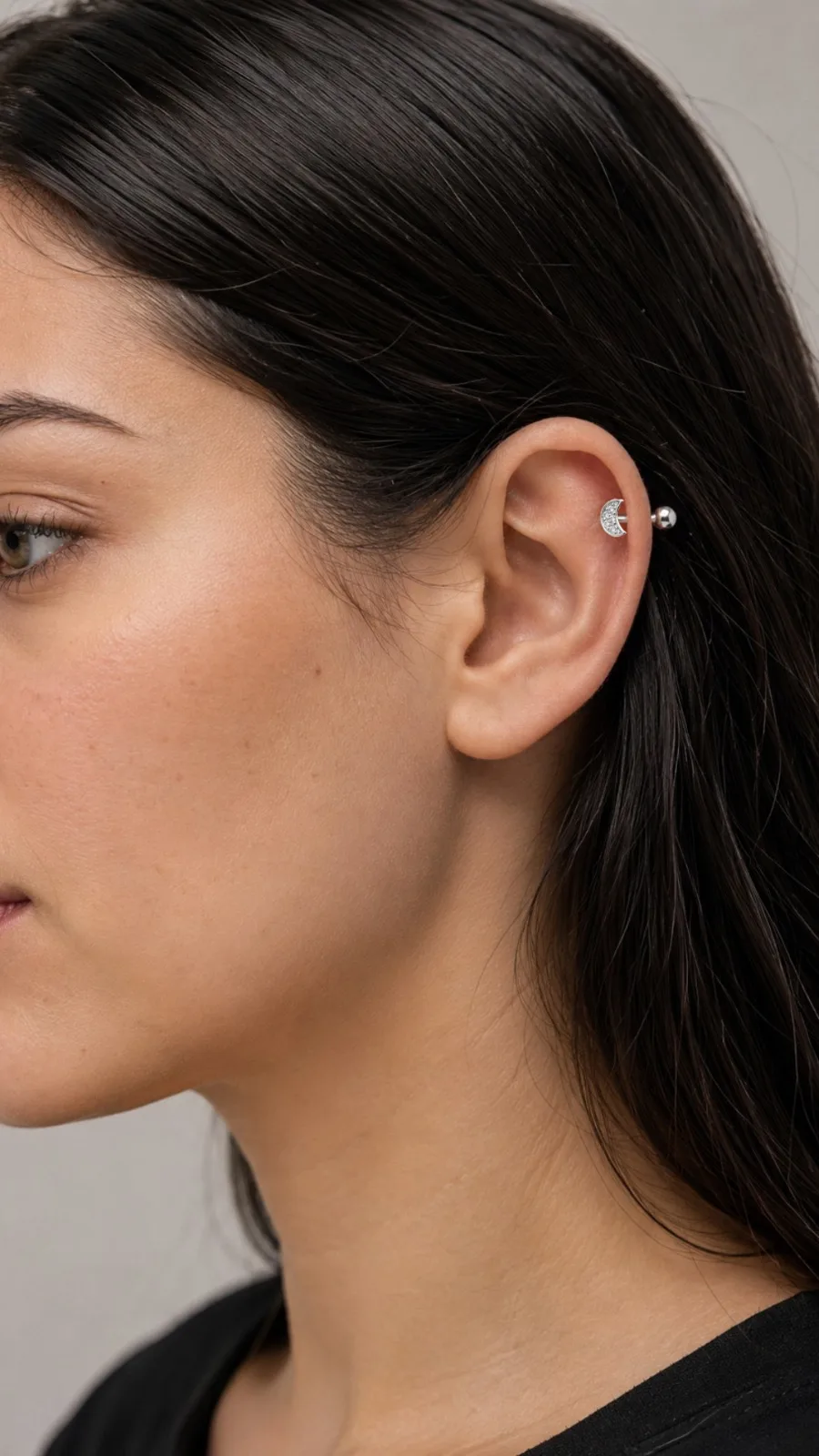Piercing reto com topo de lua cravejada e esfera.