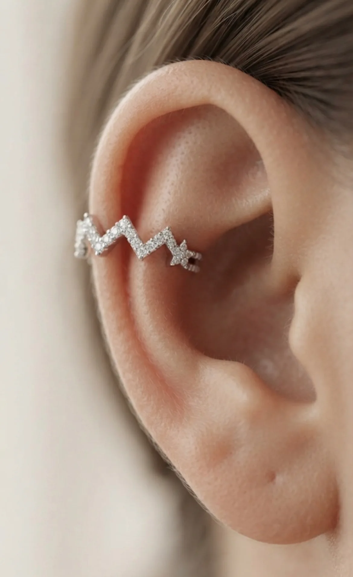 Piercing fake ajustável em formato de estrela cravejada.